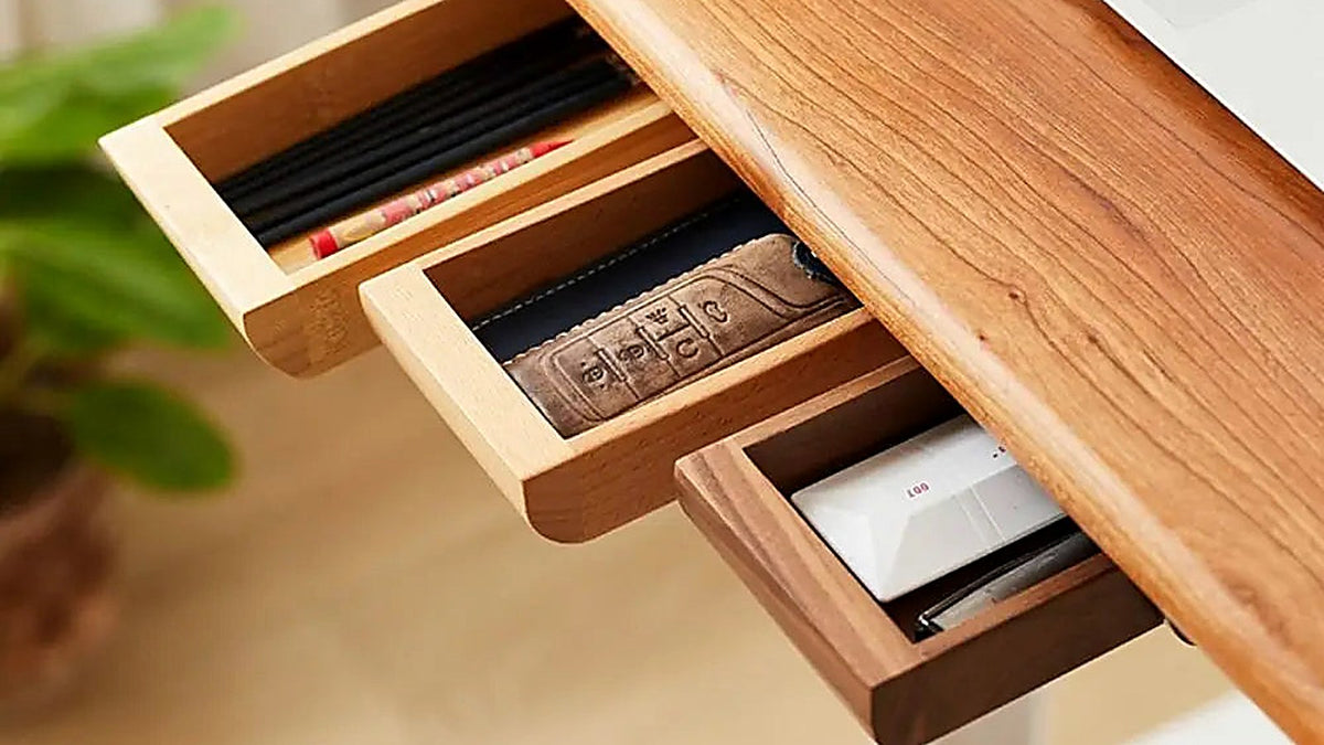 Wooden under-desk drawers pulled open, holding pens and small flat items