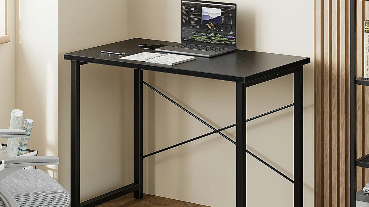 Compact black 31-inch desk with a laptop in a bright room with herringbone flooring